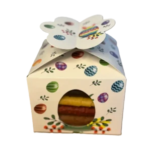 Weiße Oster-Geschenkbox mit bunten Ostereiern, Hasenohren und 'Happy Easter'-Schriftzug, dazu ein seitliches Sichtfenster.