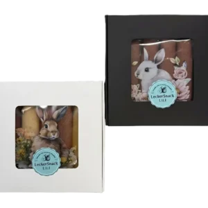Oster-Fruchtleder-Rollen in kontrastreicher weißer und schwarzer Geschenkbox mit künstlerischen Hasen-Motiven und Blumen.