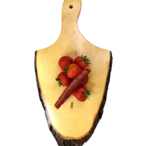 Zwei rote Erdbeer-Fruchtlederrollen auf einem Holzbrett, dekoriert mit einer Schale frischer Erdbeeren.