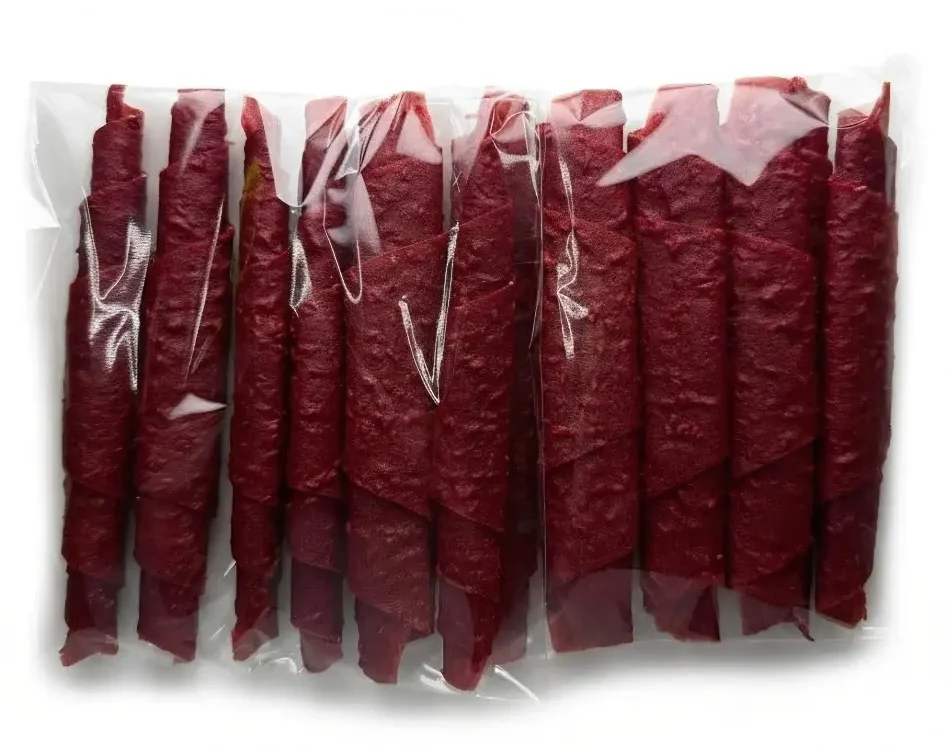 Leuchtend rote Himbeer-Fruchtlederrolle in einem Klarsichtfolie, dekoriert mit frischen, prallen Himbeeren.