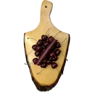 Dunkelrote Sauerkirsch-Fruchtlederrolle auf einem Holzbrett, umringt von frischen, glänzenden Sauerkirschen.