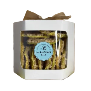 Weiße Geschenkbox mit Sichtfenster, gefüllt mit getrockneten Apfelringen, veredelt mit Mandelsplittern und Kokosraspeln.