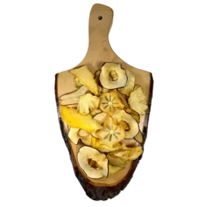 Bunte Mischung aus getrockneten Fruchtscheiben: Kaki, Mango, Orange, Melone, Apfel, Birne und Ananas auf dunklem Holz.