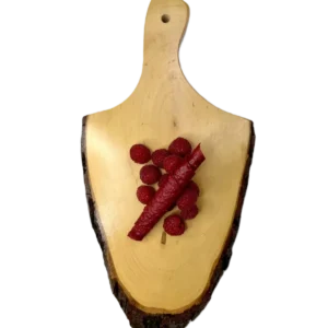 Leuchtend rote Himbeer-Fruchtlederrolle auf einem Holzbrett, dekoriert mit frischen, prallen Himbeeren.