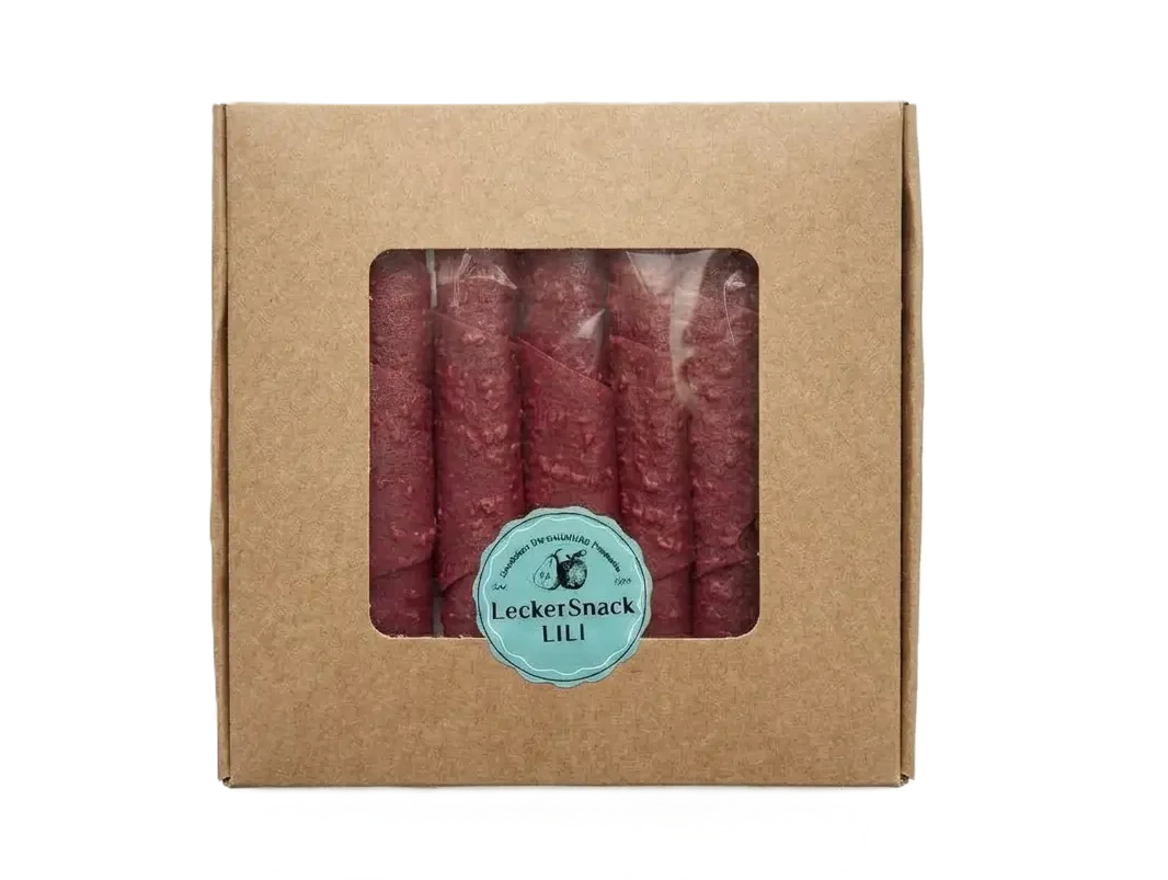 Braune Geschenkbox mit Sichtfenster, gefüllt mit zahlreichen dunkelroten Himbeer-Fruchtleder-Rollen und Siegel.