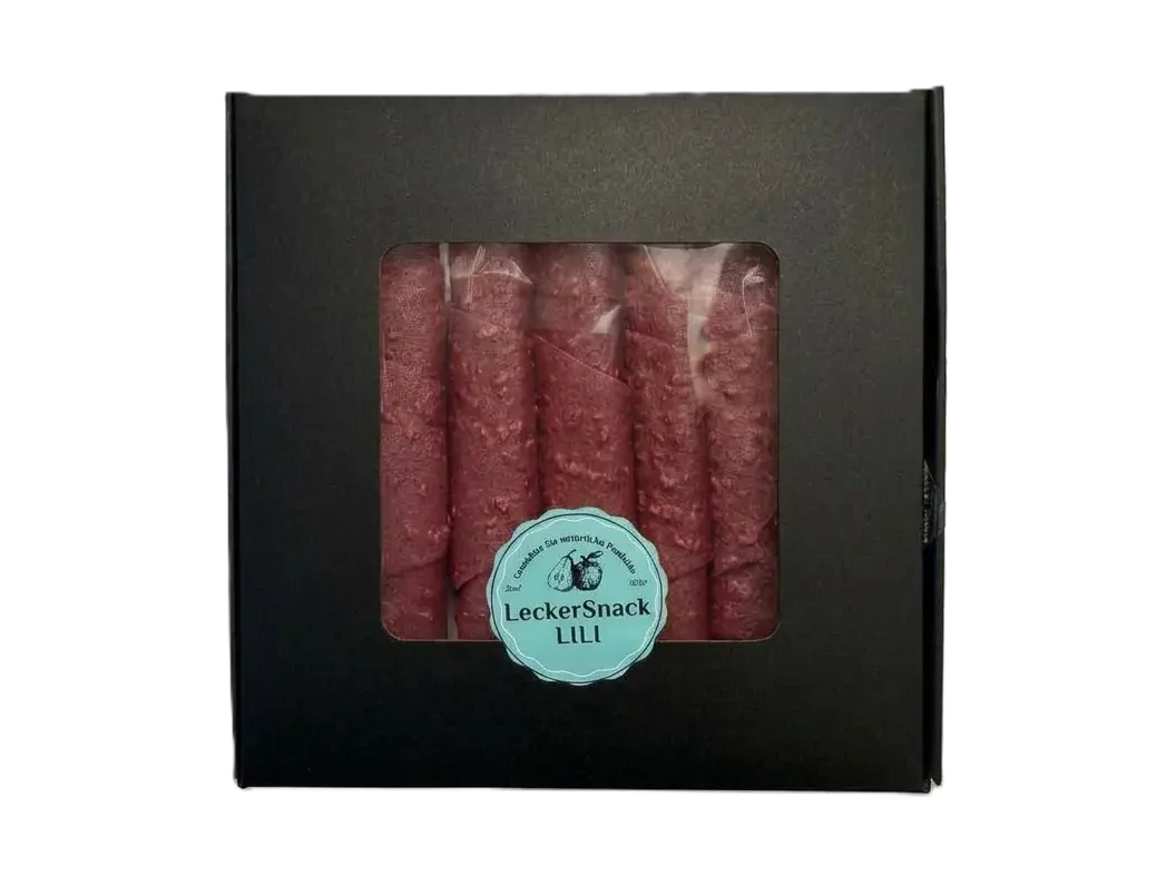 Schwarze Geschenkbox mit Sichtfenster, gefüllt mit zahlreichen dunkelroten Himbeer-Fruchtleder-Rollen und Siegel.