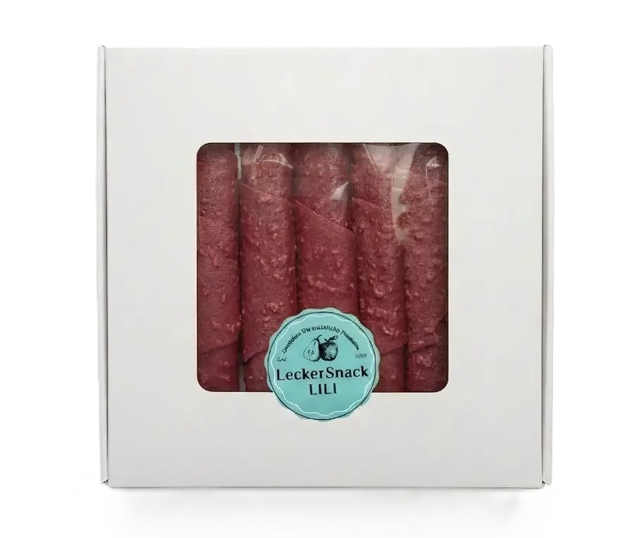 Weiße Geschenkbox mit Sichtfenster, gefüllt mit zahlreichen dunkelroten Himbeer-Fruchtleder-Rollen und Siegel.