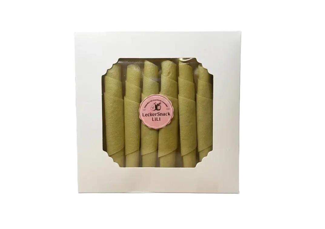 Weiße Geschenkbox mit Sichtfenster, gefüllt mit hellorangefarbenen Melonen-Fruchtleder-Rollen und LeckerSnackLILI Siegel.