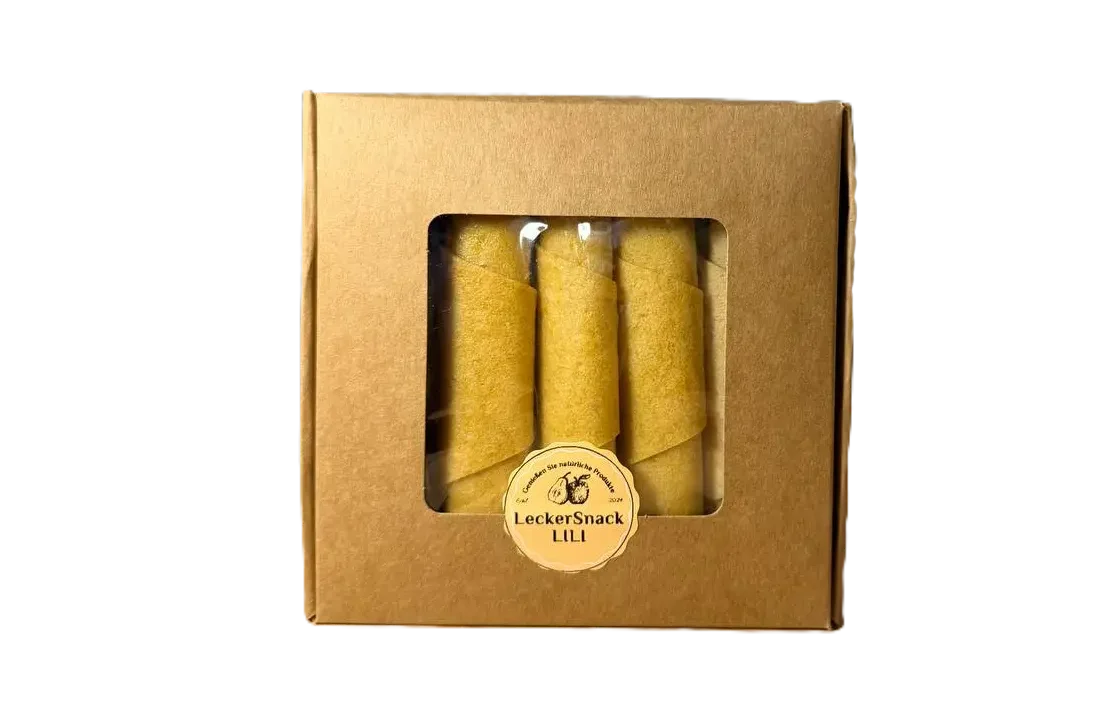 Braune Fensterbox mit leuchtend orangen Fruchtleder-Rollen und rundem LeckerSnack Lili Siegel.