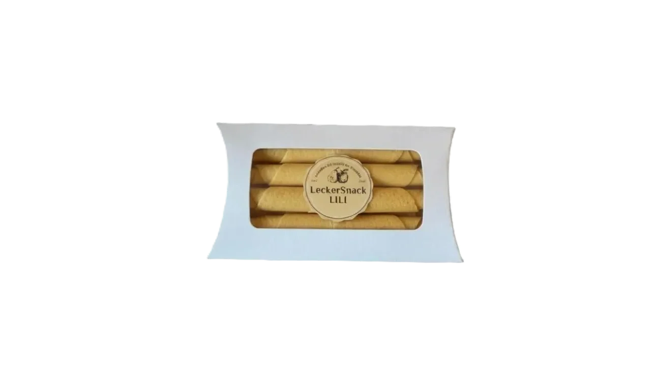 Weiße Fensterbox mit leuchtend orangen Fruchtleder-Rollen und rundem LeckerSnack Lili Siegel.