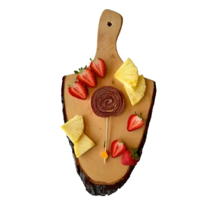 Erdbeer-Ananas Fruchtleder-Lolli Spirale auf einem Servierbrett aus Holz mit Ananas und Erdbeeren auf ihm